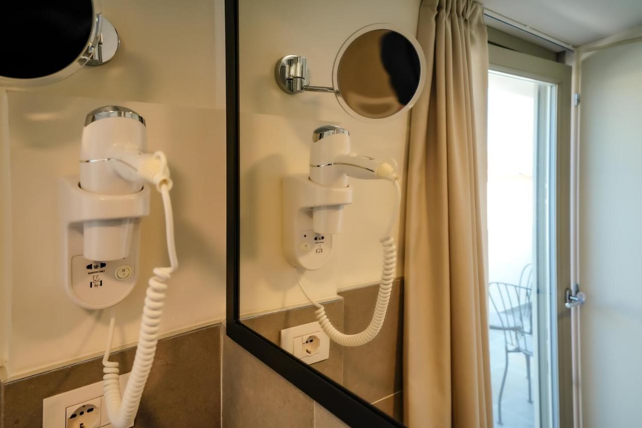 Bergamo Inn 15 Luaran gambar A wall-mounted hair dryer in a hotel room